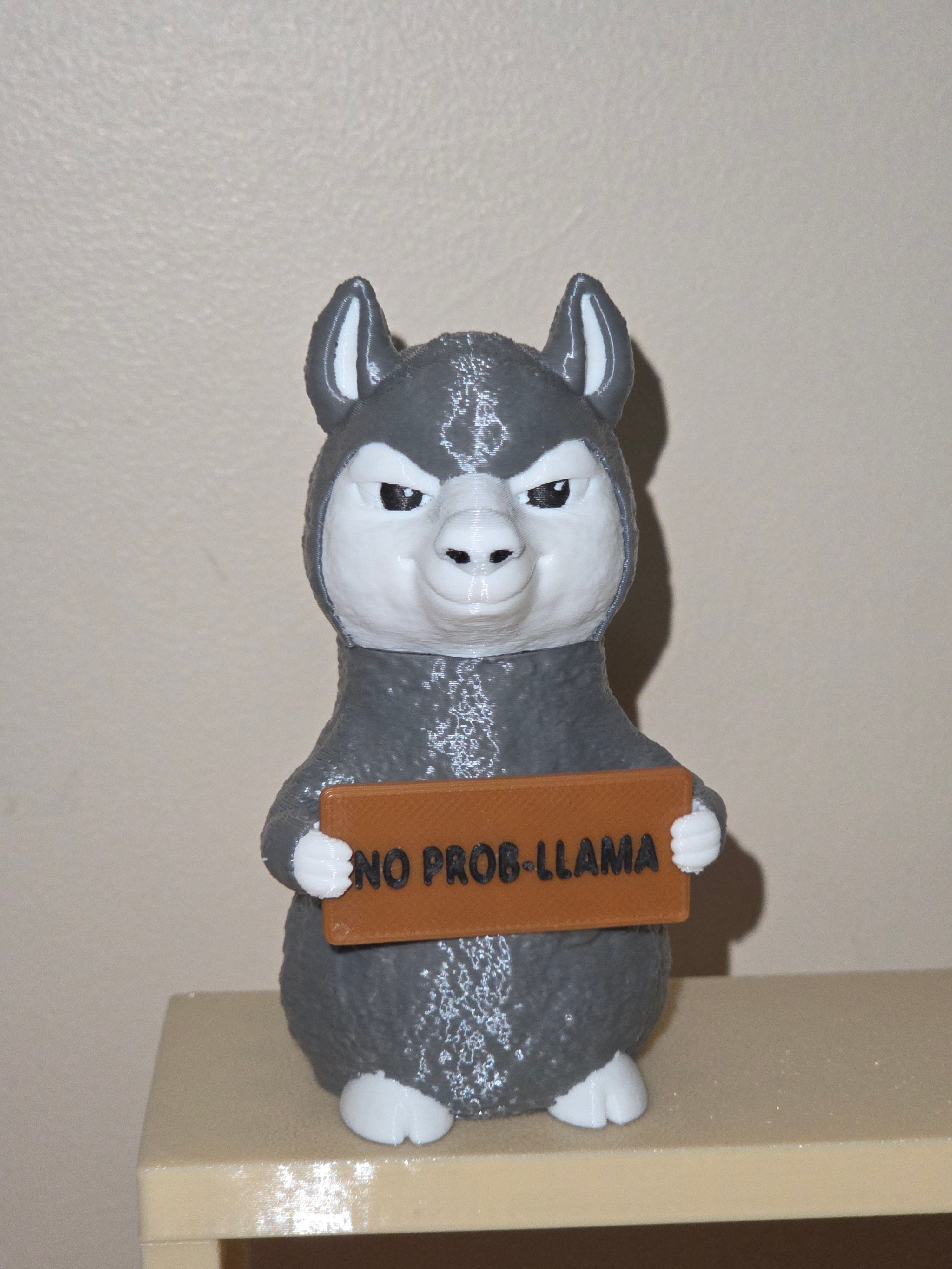 Gray llama holding a sign that says NO PROB-LLAMA