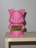 Grumpy pink pig holding a sign that says Oink If I Care